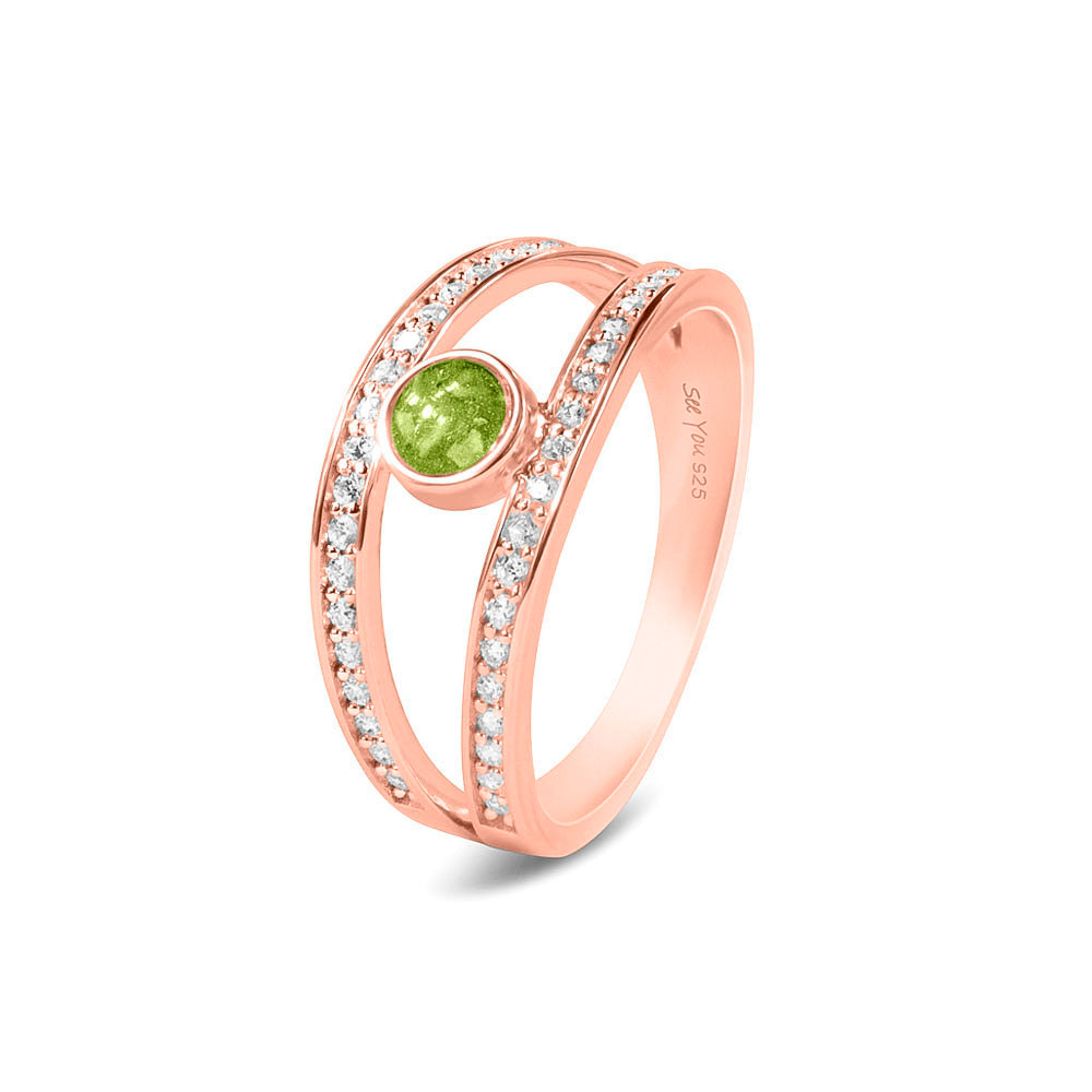 Gedenksieraad, ring waar aan de bovenzijde zichtbaar as of haar verwerkt wordt. In de bovenste helft van de ringband zijn subtiel edelstenen naar keuze gezet. Green