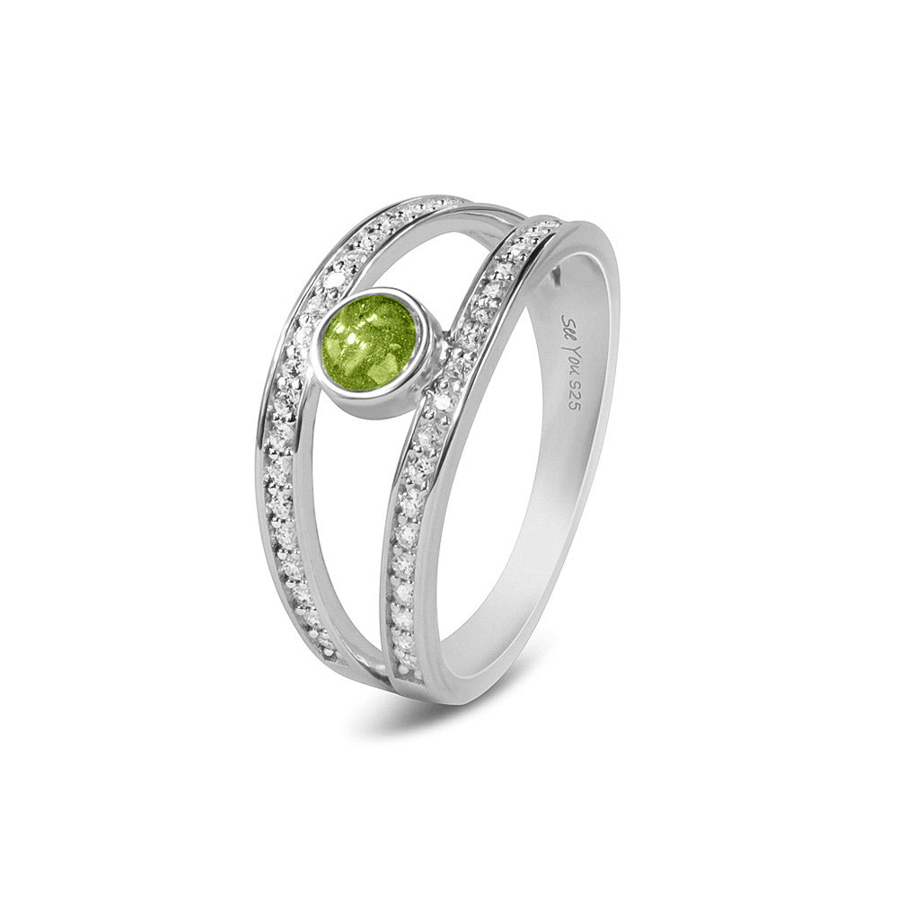 Gedenksieraad, ring waar aan de bovenzijde zichtbaar as of haar verwerkt wordt. In de bovenste helft van de ringband zijn subtiel edelstenen naar keuze gezet. Green