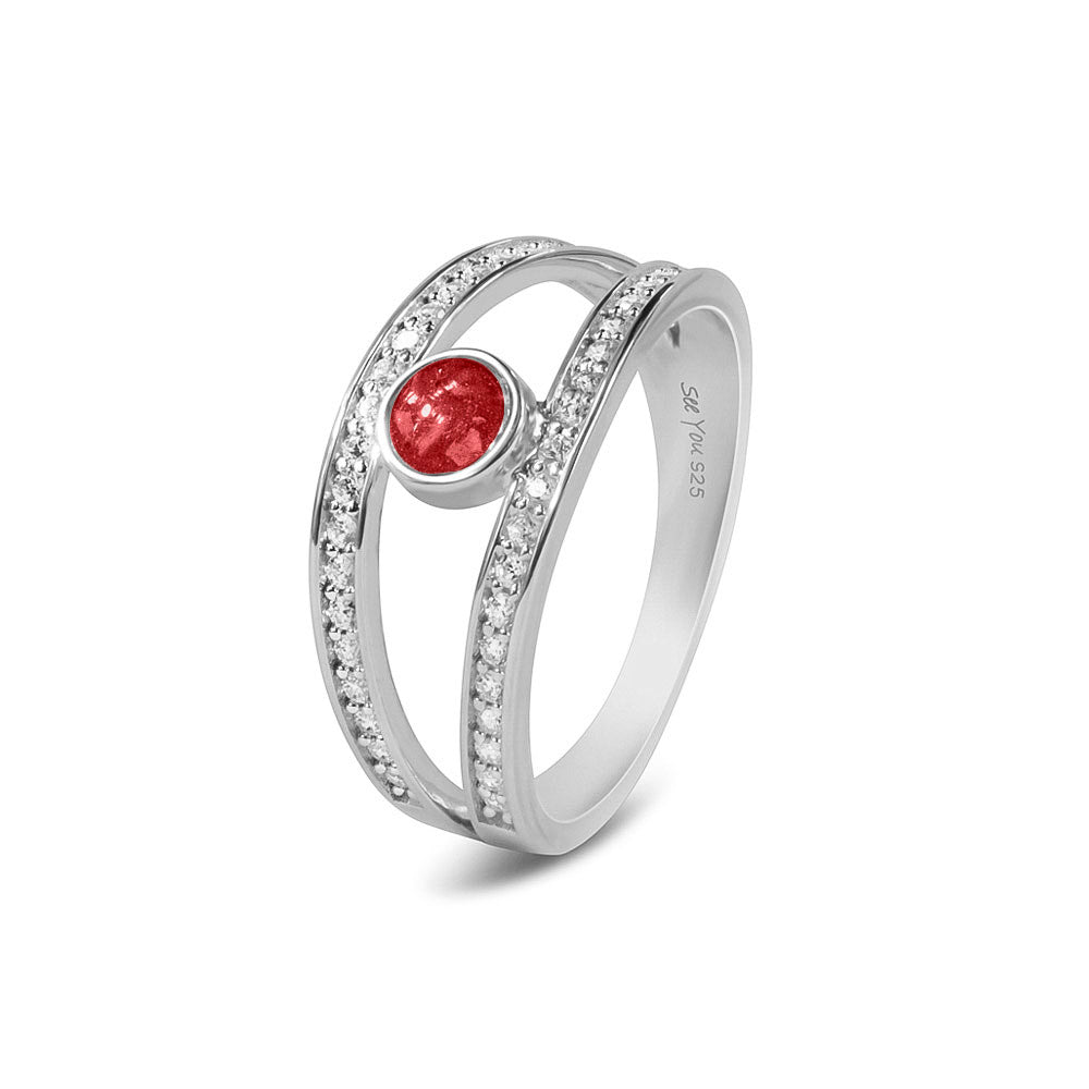 Gedenksieraad, ring waar aan de bovenzijde zichtbaar as of haar verwerkt wordt. In de bovenste helft van de ringband zijn subtiel edelstenen naar keuze gezet. Red