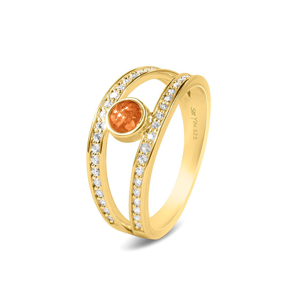 Gedenksieraad, ring waar aan de bovenzijde zichtbaar as of haar verwerkt wordt. In de bovenste helft van de ringband zijn subtiel edelstenen naar keuze gezet. Orange