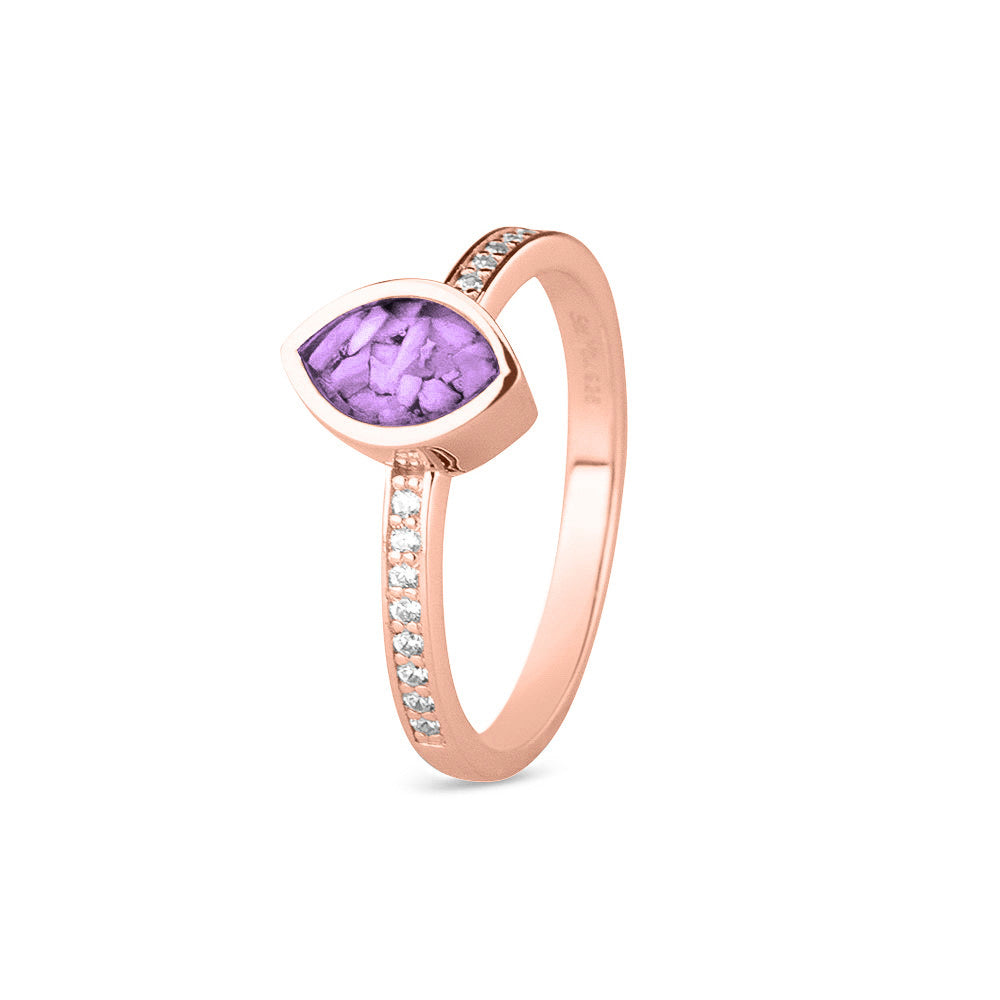 Gedenksieraad, ring 3 mm breed waar aan de bovenzijde zichtbaar as of haar verwerkt wordt. In de ringband zijn subtiel edelstenen naar keuze gezet. Purple