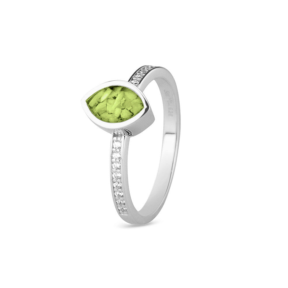 Gedenksieraad, ring 3 mm breed waar aan de bovenzijde zichtbaar as of haar verwerkt wordt. In de ringband zijn subtiel edelstenen naar keuze gezet. Green
