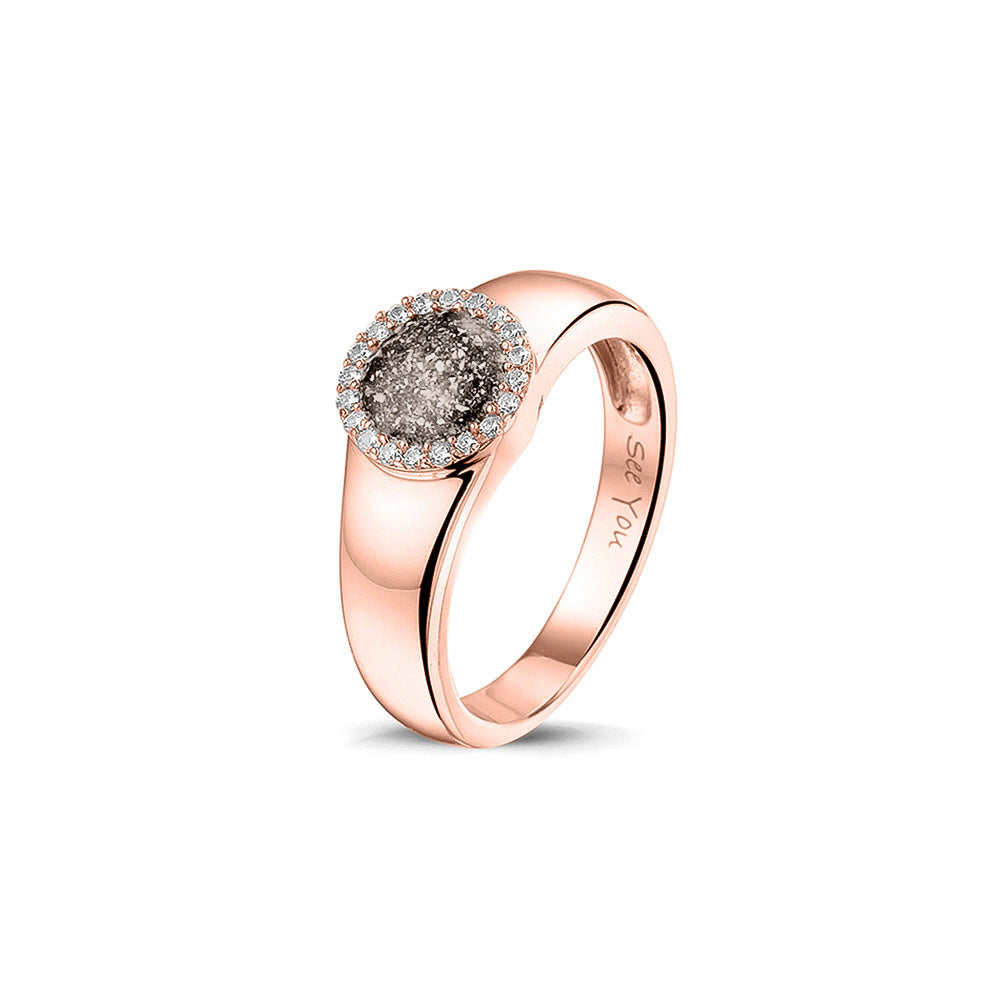 Gedenksieraad, gladde ring waar aan de bovenzijde zichtbaar as of haar verwerkt wordt in een rondje, rondom gezet met zirkonia's of diamanten naar keuze. Silver