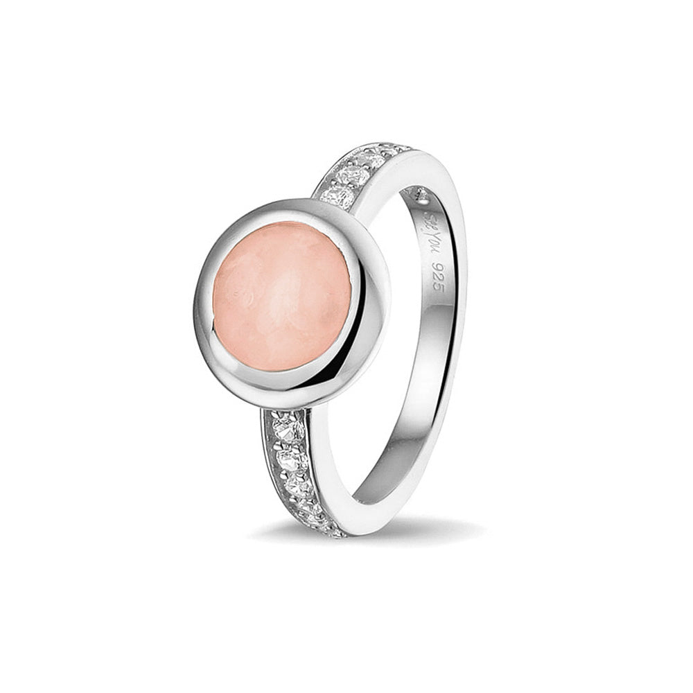 Gedenksieraad, ring 3 mm waar aan de bovenzijde zichtbaar as of haar verwerkt wordt. In de bovenste helft van de ringband zijn zirkonia's of diamanten naar keuze gezet.  Blush
