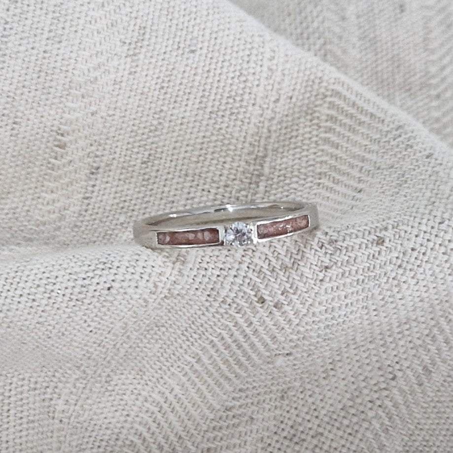 Gedenksieraad, ring 3 mm met (zirkonia of diamant), geflankeerd door twee compartimenten waar zichtbaar as of haar  in verwerkt wordt. Alle