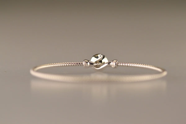 Zilveren as armband met in het midden een ornamentje, gedenksieraad, alle