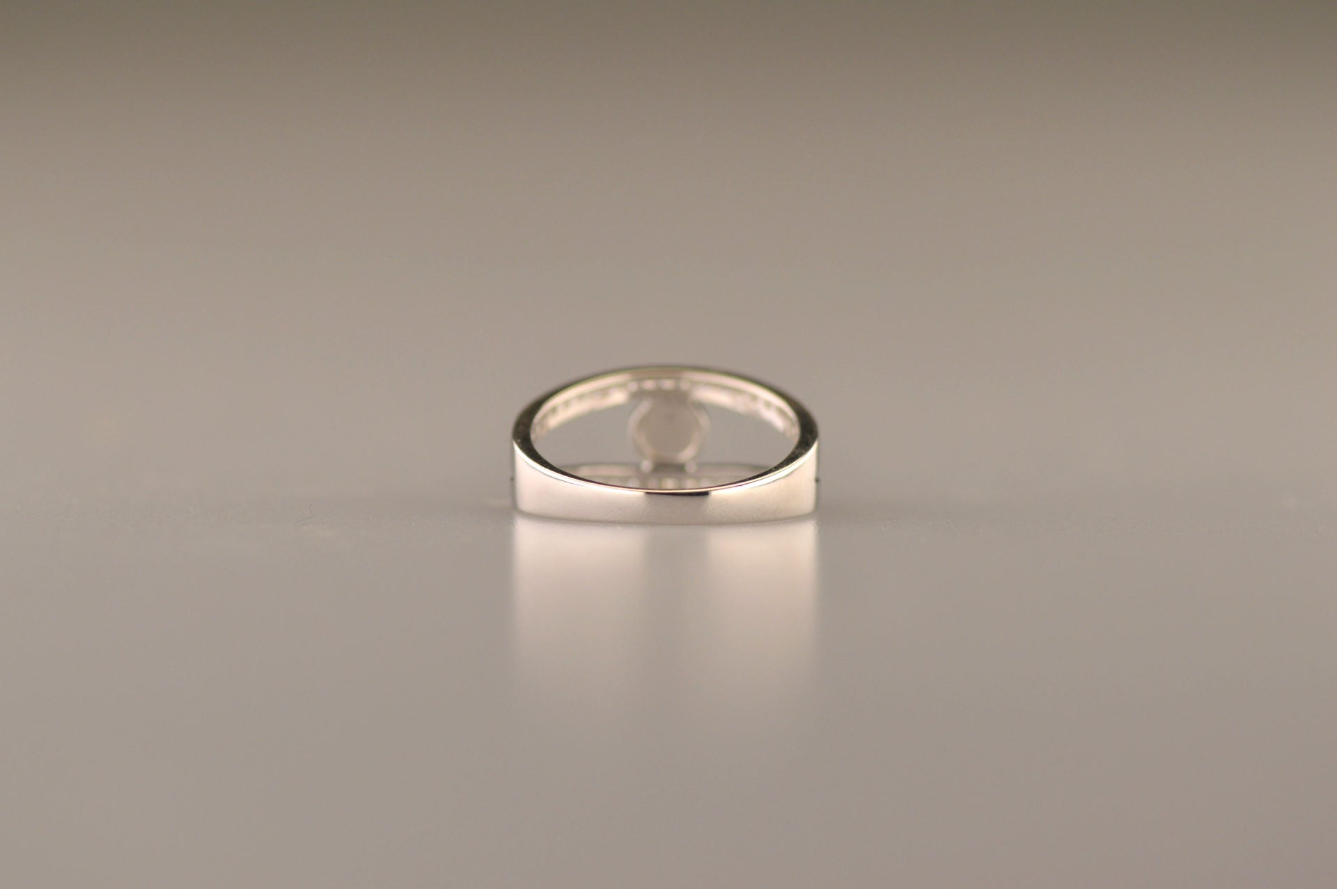 Gedenksieraad, ring waar aan de bovenzijde zichtbaar as of haar (of eventueel melktandjes of moedermelk) verwerkt wordt. In de bovenste helft van de ringband zijn subtiel edelstenen naar keuze gezet. 