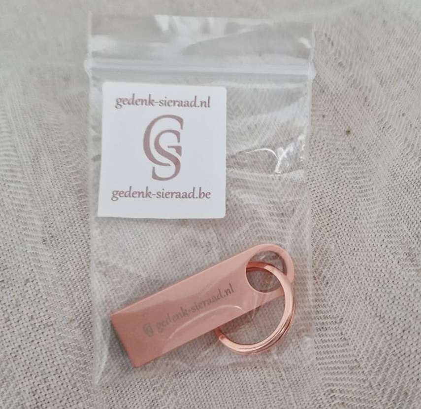 USB stick 16 GB/3.0 flash drive. Afmetingen: 38,5x12x4,5 mm. Kleur : rosé gold. Opdruk : gedenk-sieraad.nl. Inclusief sleutelhanger split ring in rosé gold kleur.alle
